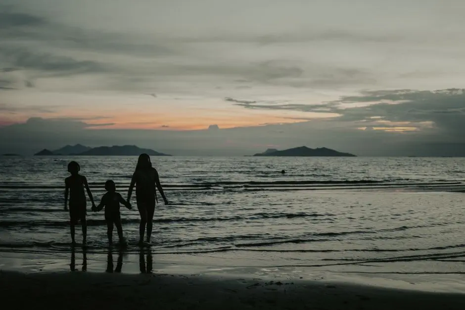 Keluarga bermain air di tepi pantai saat senja