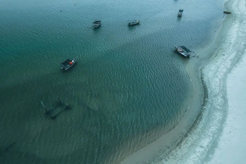 Pemandangan Pantai Waisailissa dengan pasir putih dan perahu nelayan
